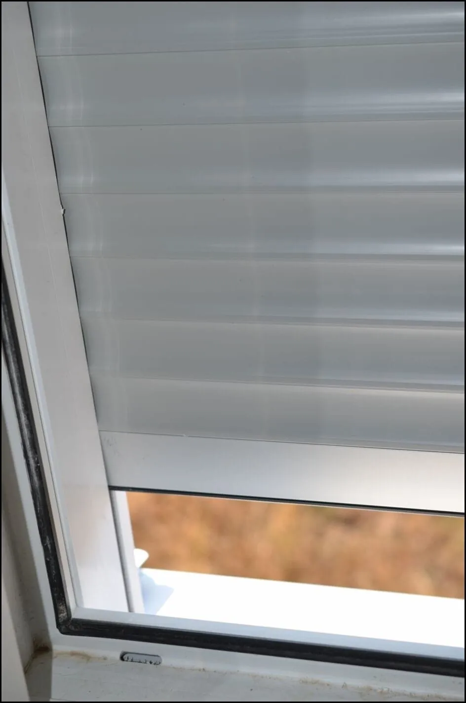 Der Rollladen ist zu klein – er kann bei Wind aus den Schienen herausfallen. Die Rollladen-Führungsschiene ragt ins Fenster.