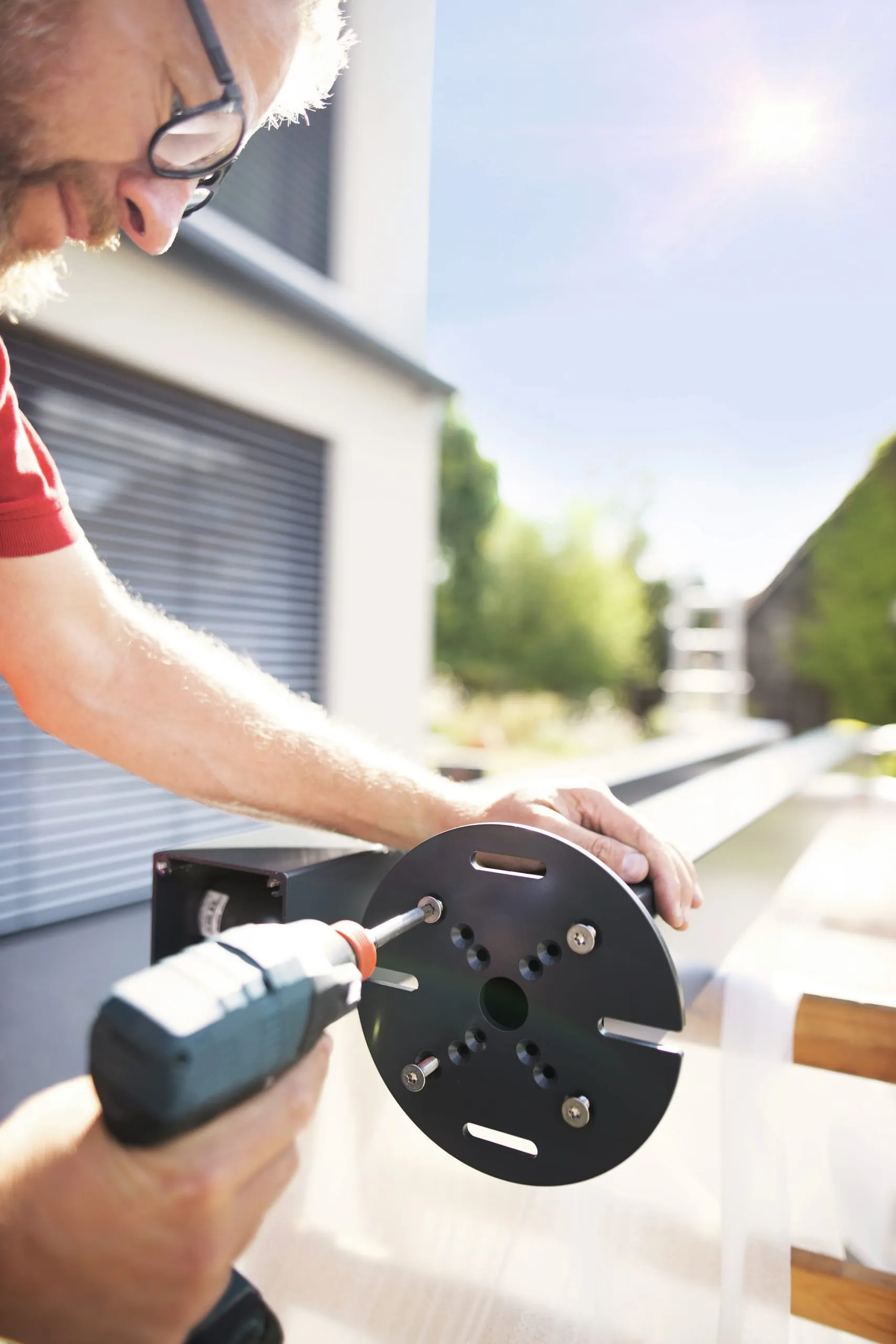 Bereiten Sie die Pfosten für die Montage vor, indem Sie die Grundplatten anschrauben.