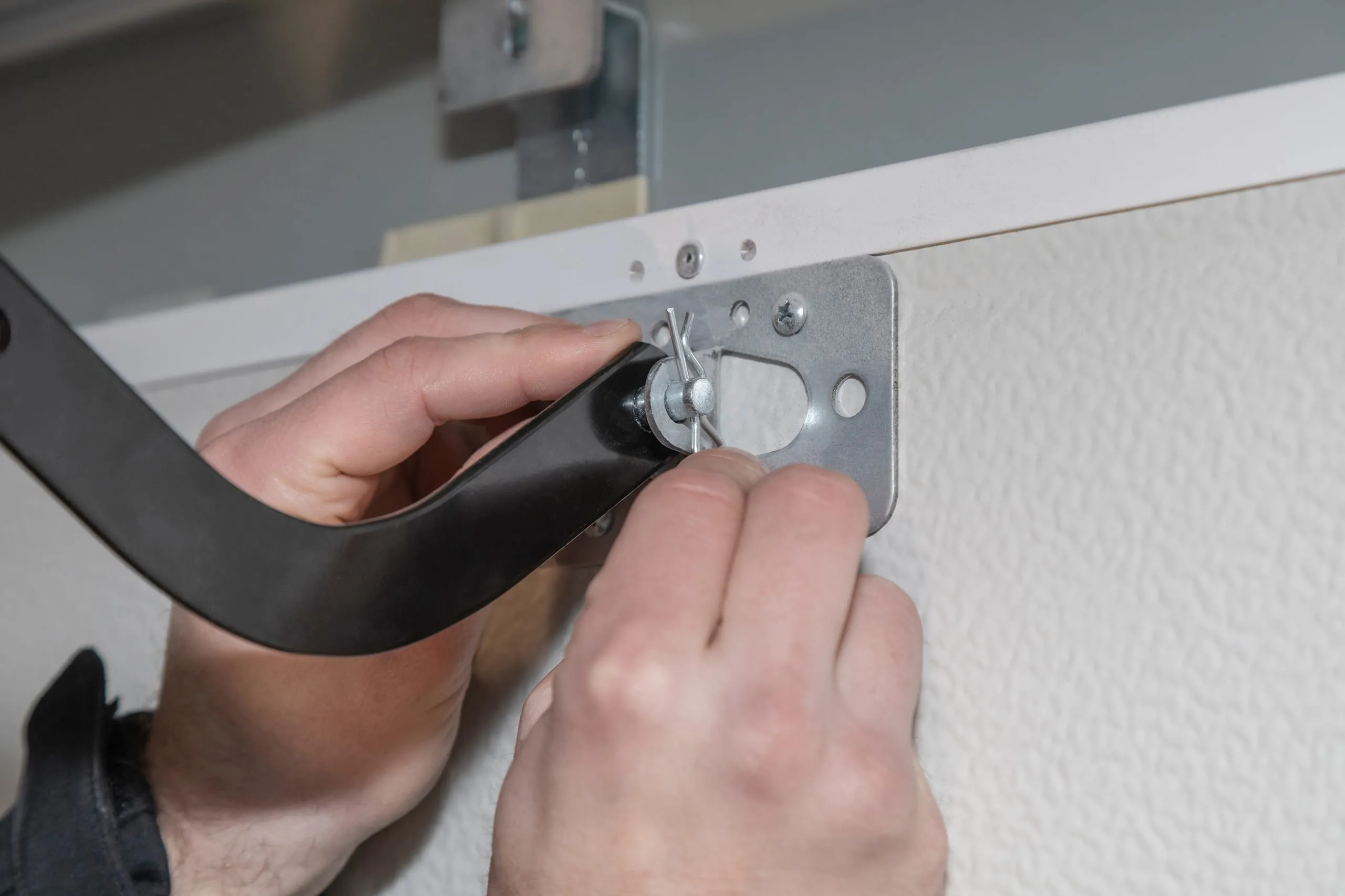 Verbinden Sie den Torarm am Schlitten in der Schiene mit der Torbefestigung.