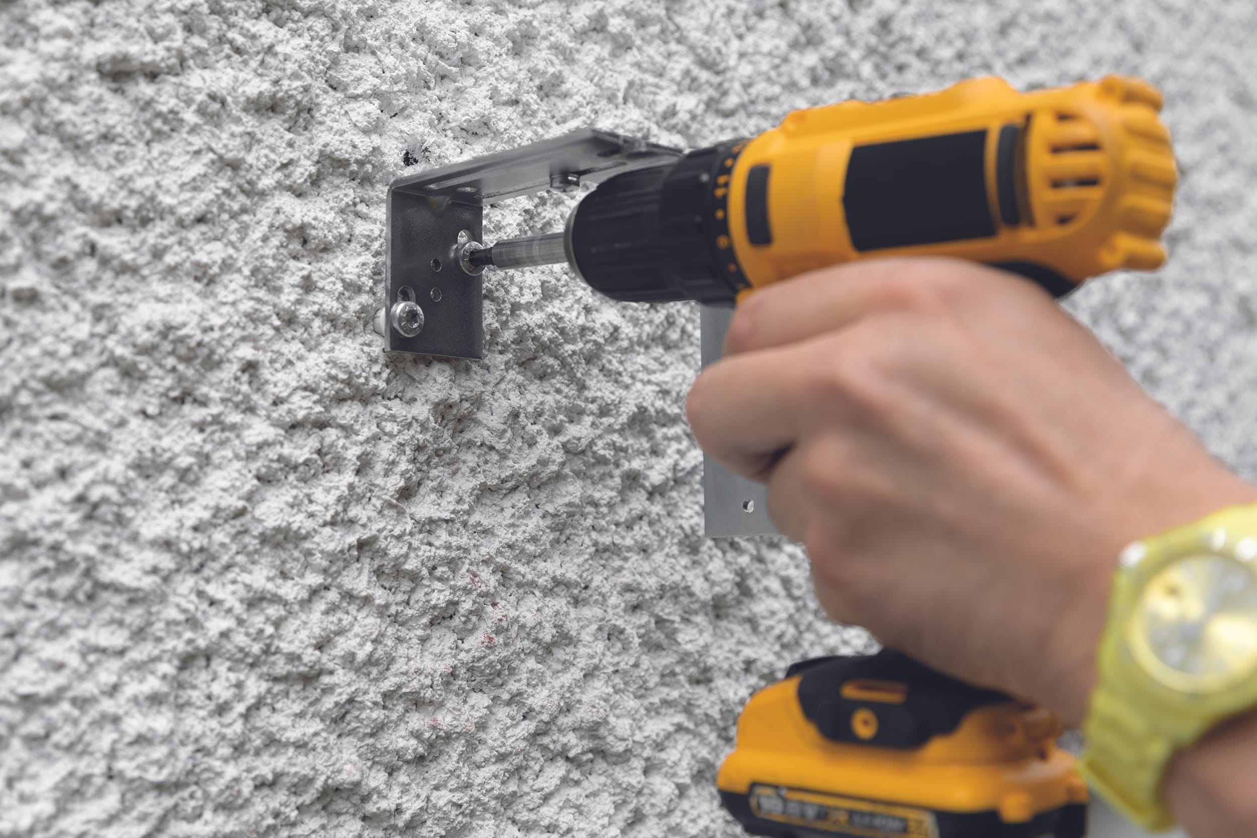 Bringen Sie für den Bauuntergrund geeignete Dübel an. Bringen Sie die Montagebügel in die Waage und schrauben Sie sie an.