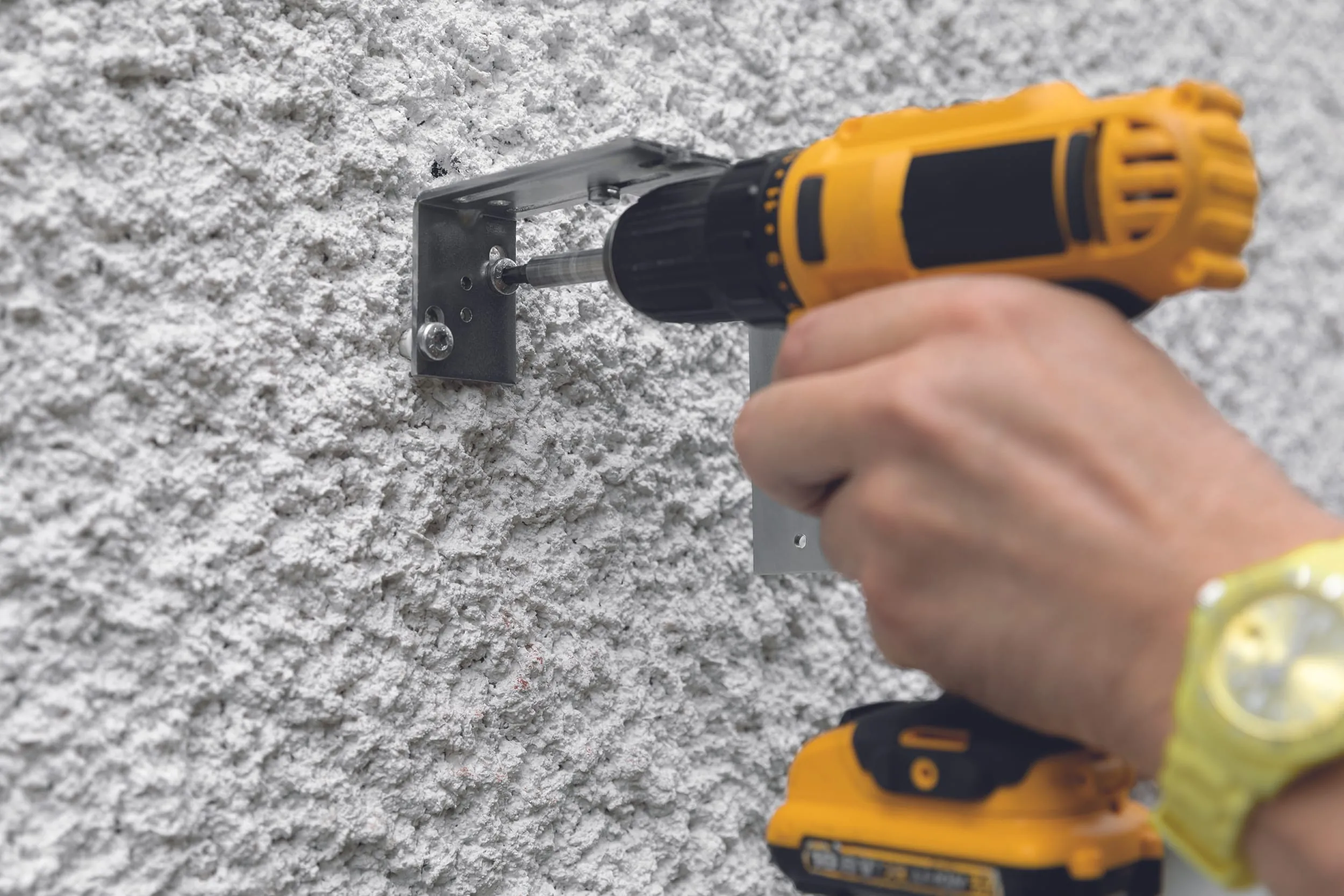 Bringen Sie für den Bauuntergrund geeignete Dübel an. Bringen Sie die Montagebügel in die Waage und schrauben Sie sie an.