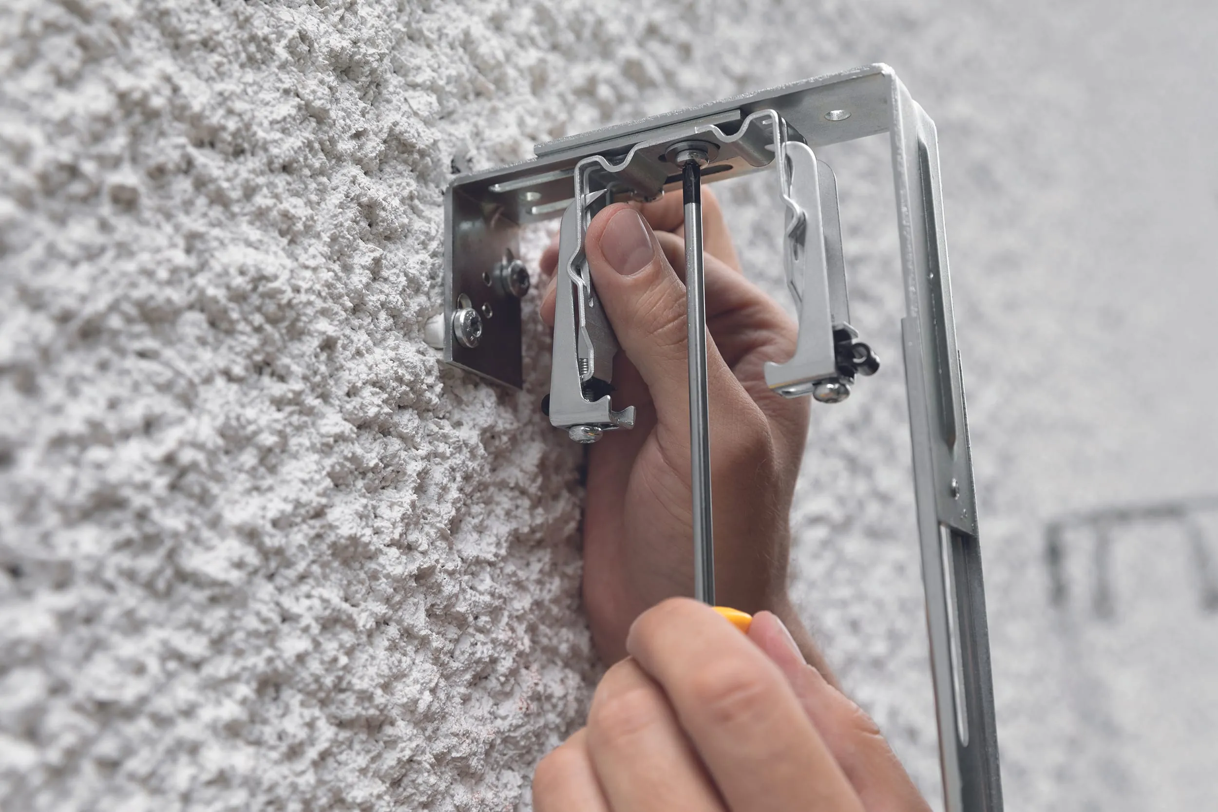 Bringen Sie den Oberschienenhalter mit Federmechanismus jeweils von unten am Montagebügel an.