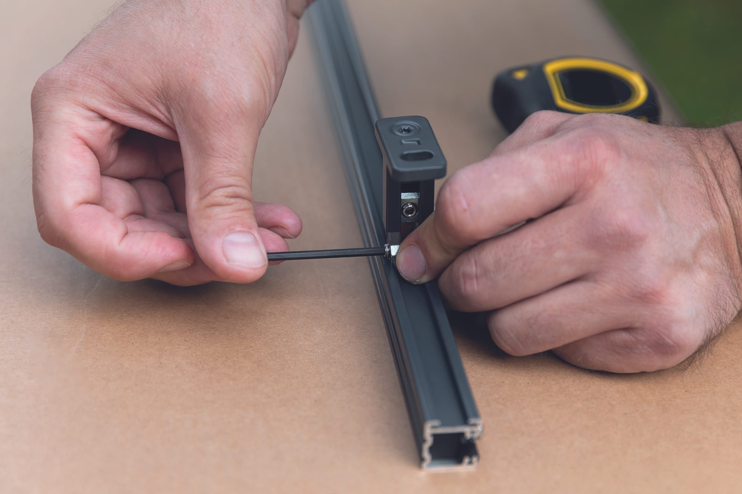 Positionieren Sie die Führungsschienenhalter in den Schienen. Ziehen Sie sie fest und versehen Sie die Führungsschienen mit Endstopfen.