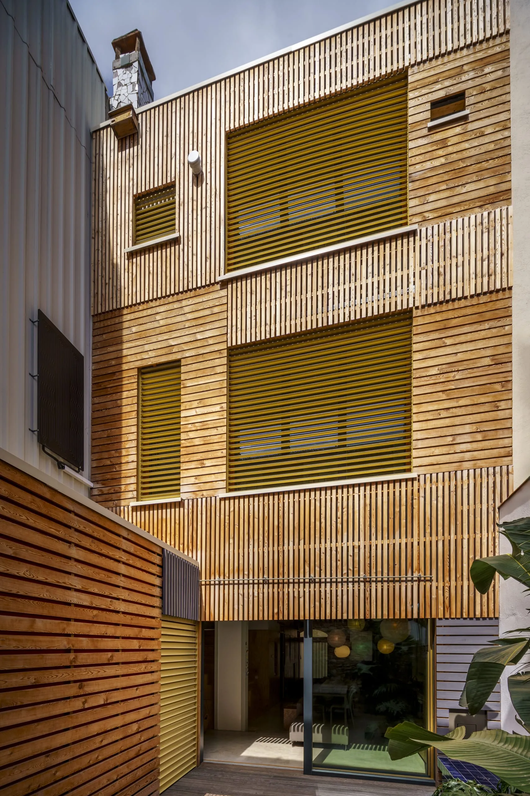 Die hintere Fassade des Wohnhauses zeichnet sich durch Lärchenholz aus, in die sich die Lamellenstoren hervorragend einfügen.