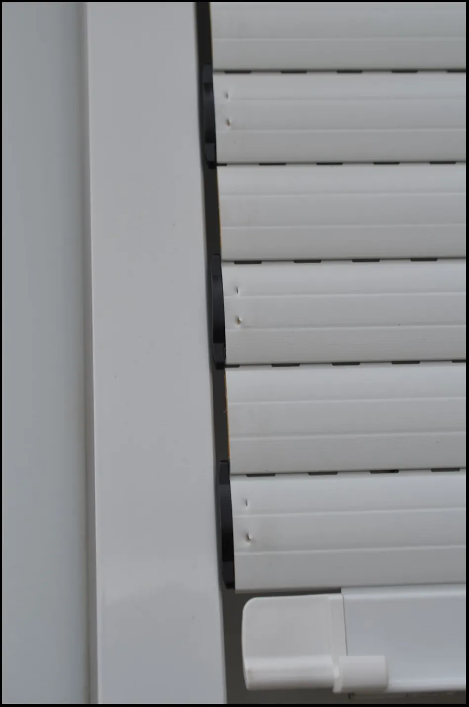 Einer der Rollladen ist aus der seitlichen Führungsschiene gesprungen. Diese ist nicht richtig befestigt.