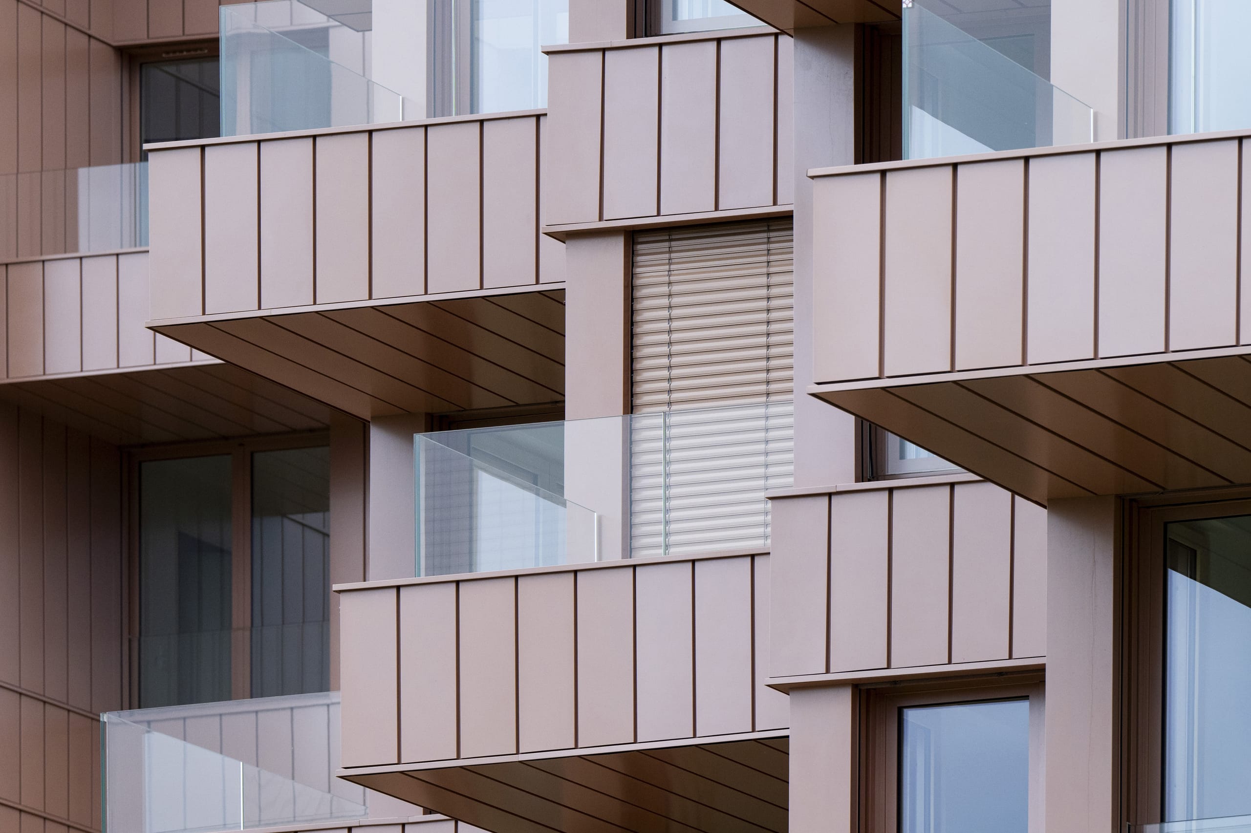 Insgesamt wurden 265 Lamellenstoren Lamisol 70, sieben Grinotex III und 108 Rollläden Tradi Pur eingesetzt. Um eine optische Harmonie zu erreichen, fiel die Farbwahl der Sonnenschutzprodukte auf zu den Wohnobjekten passende Farbtöne. Sowohl für die beiden Lamellenstoren-Modelle als auch die Rollläden entschieden sich die Architekten für einen metallischen Rosaton, der eigens für dieses Projekt entwickelt wurde.