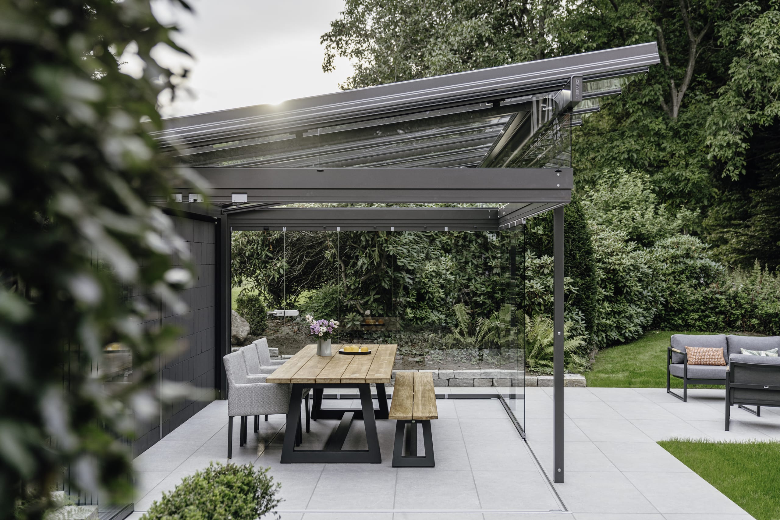 Die Grundfläche des Glashauses beträgt knapp 22 Quadratmeter. Zusätzlich wurde die Terrasse ringsherum weiter gepflastert, um mehr Fläche zu schaffen. Als Terrassendach-Konstruktion fiel die Wahl auf das Aluminiumsystem SDL Atrium Plus, mit dem große Glasflächen und Stützweiten realisiert werden können. Dazu sind nahezu alle Dachformen und optional seitliche Dachüberstände möglich. Hier wurde ein Pultdach, mit einer Neigung von neun Grad gewählt.