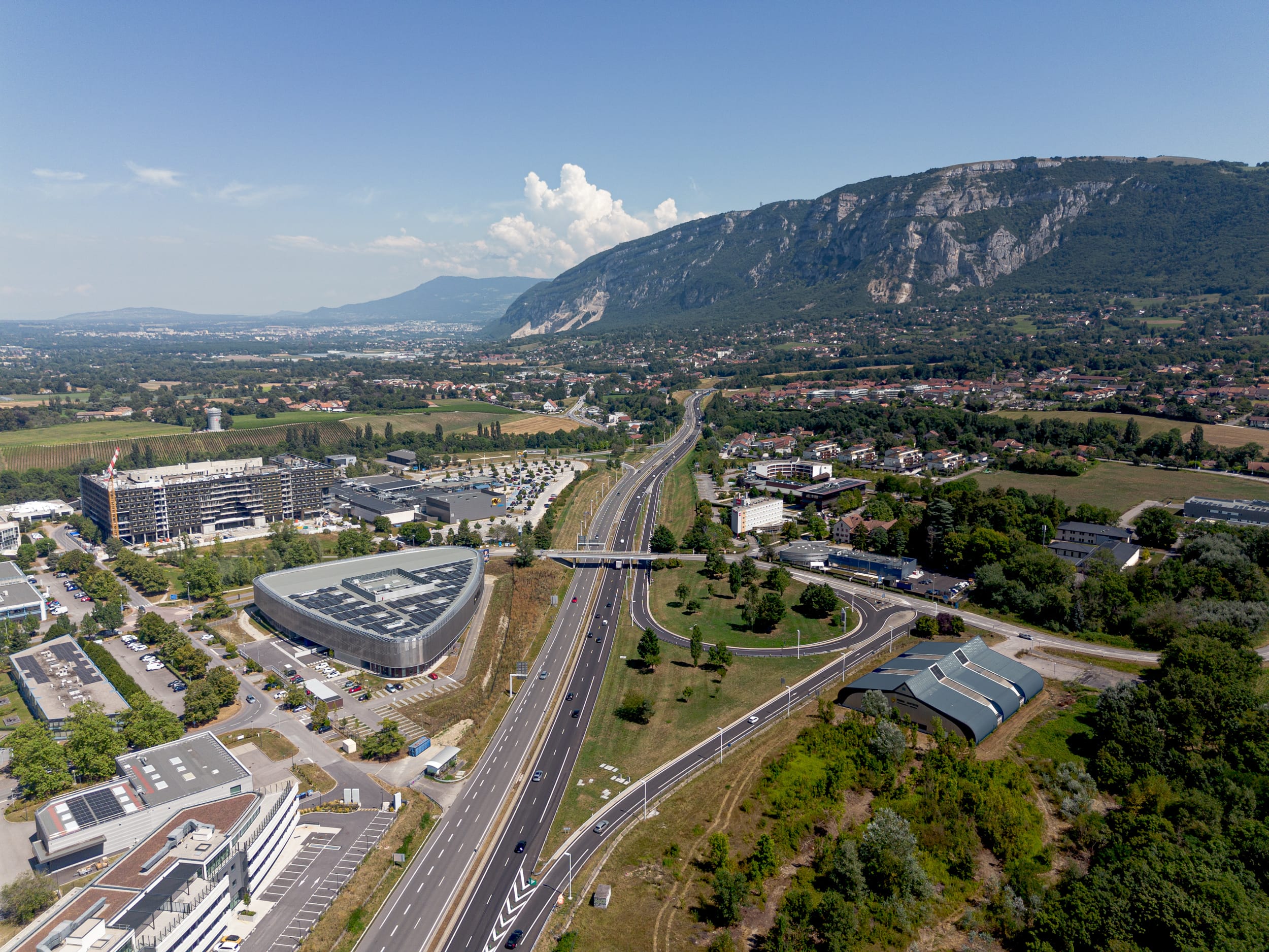 Die umlaufende Gewebefassade besticht durch ihr harmonisches und durchgängiges Design. Der dreieckige Grundriss des Gebäudes mit seinen abgerundeten Ecken stellte hohe Anforderungen an die Planung und Fertigung der Gewebefassade. Besondere Herausforderungen wie die Integration der Firmenlogos verdeutlichen den maßgeschneiderten Charakter dieses Projekts.