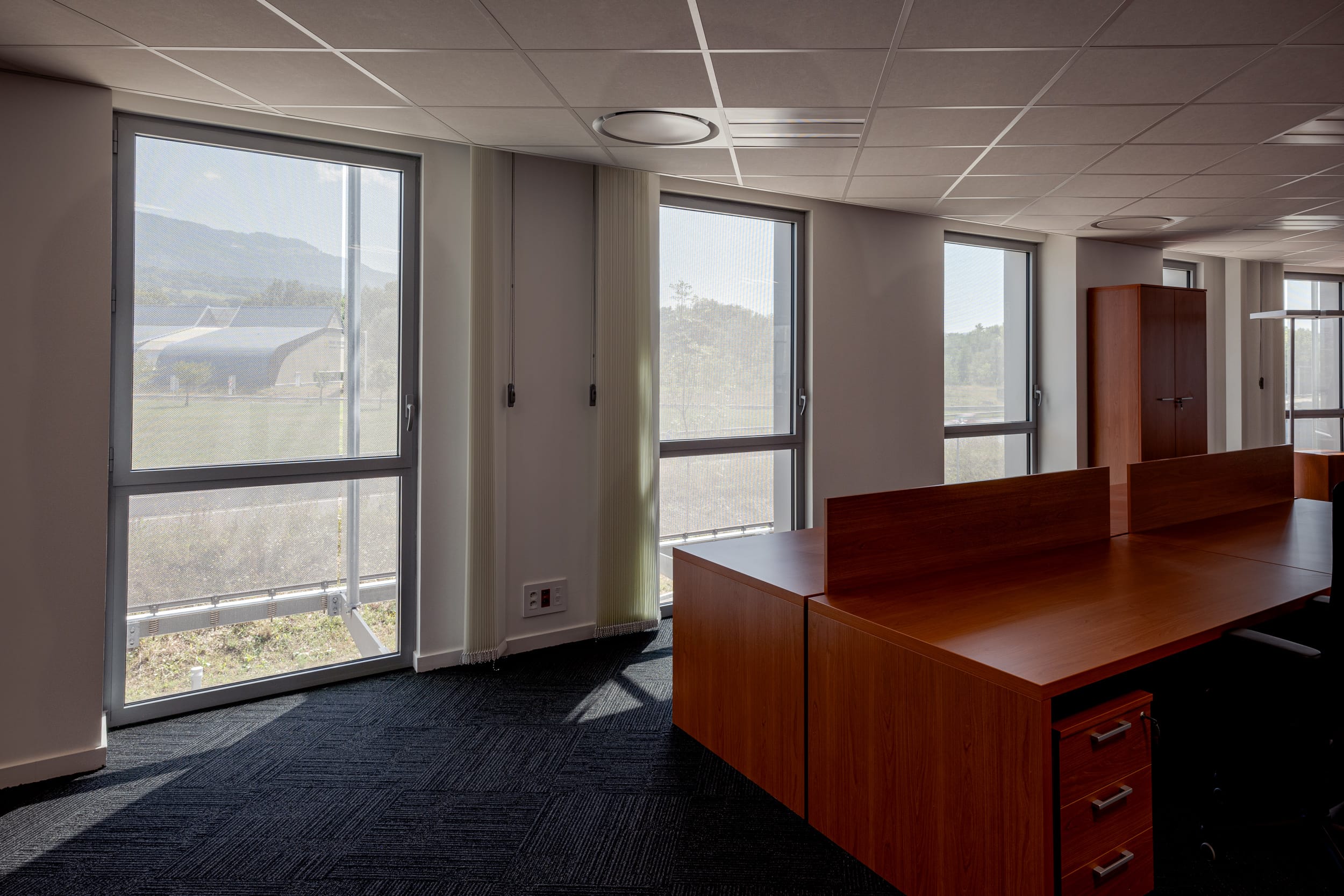 Ein wesentlicher Vorteil der Fassadenstruktur aus Drahtgewebe ist der effiziente Sonnenschutz. Die offene Gewebestruktur von 28 Prozent reduziert signifikant die direkte Sonneneinstrahlung, ohne die natürliche Belichtung und Durchsicht zu beeinträchtigen. Dies trägt nicht nur zu einem angenehmen Raumklima bei, sondern senkt auch die Energiekosten für die Klimatisierung.