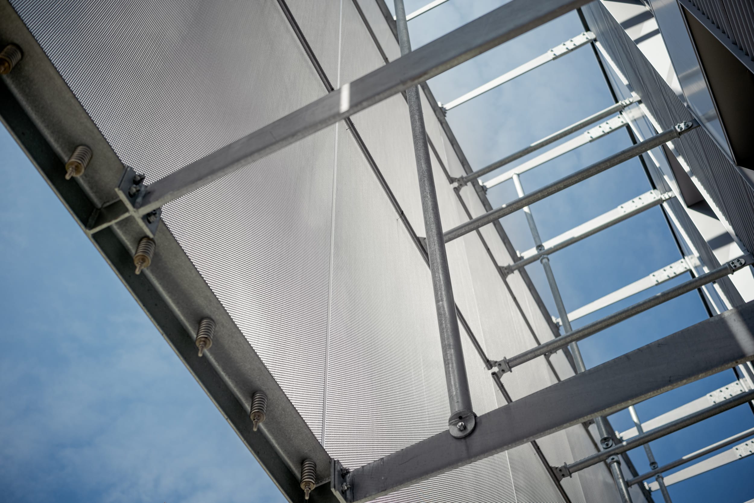 Die Fassadenverkleidung des Gebäudes wurde mit insgesamt 160 maßgefertigten Gewebe-Elementen realisiert, die eigens von Haver & Boecker für dieses Bauprojekt hergestellt wurden. Jedes Element zeichnet sich durch eine Höhe von 8,5 Metern und variierende Breiten zwischen 1,1 und 2,4 Metern aus. Für die Montage kam die bewährte Haver Befestigungslösung zum Einsatz.