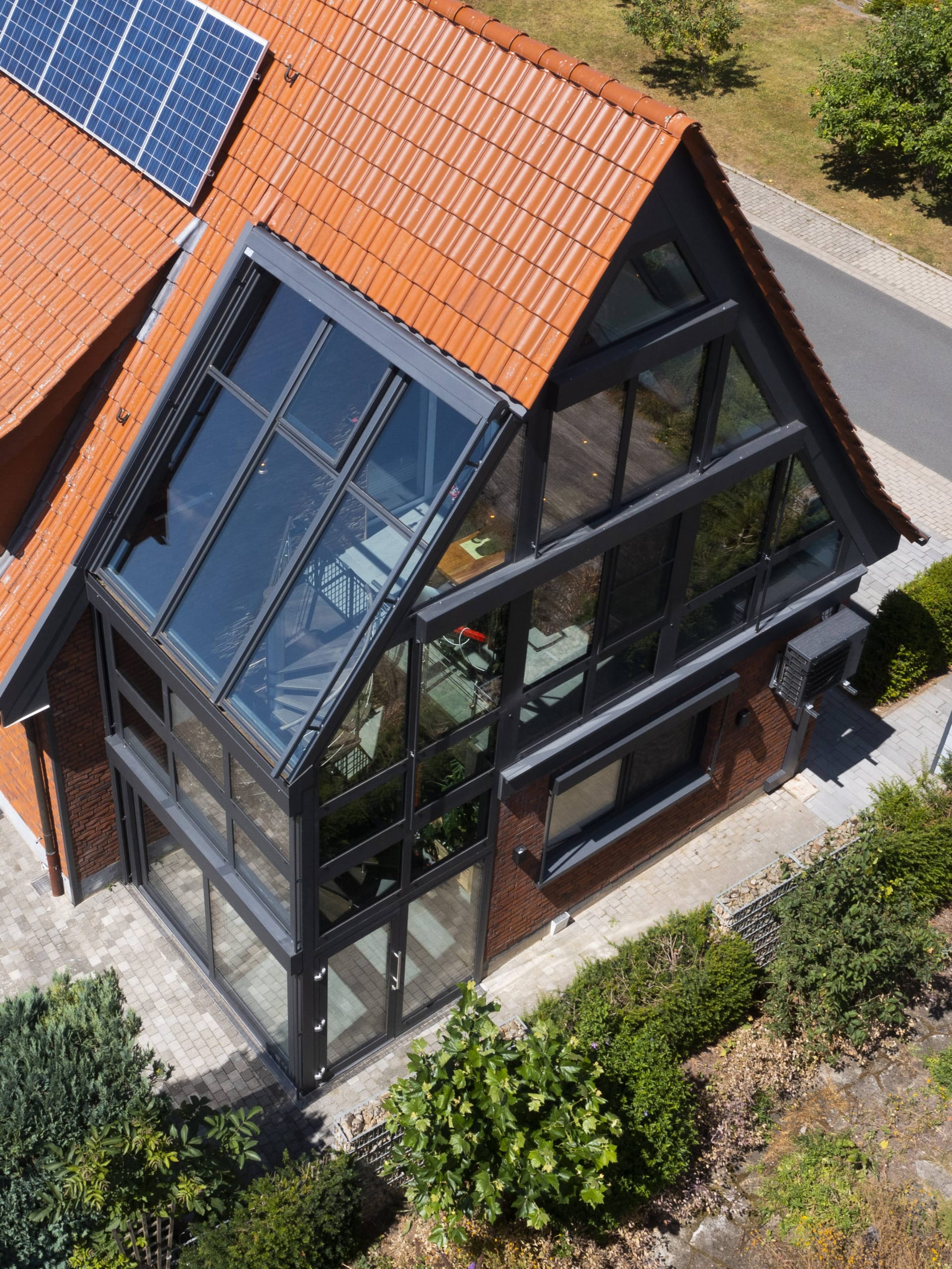 Nach seinem Umbau präsentiert sich ein Einfamilienhaus in Ennigerloh mit einem Wintergarten über zwei Etagen. Eine Wendeltreppe verbindet innen Erd- und Obergeschoss. Bei der Umsetzung beraten wurden die Bauherren und die Planer von TS-Aluminium, die auch die Profilsysteme und Stripe-Beleuchtung lieferten und den ausführenden Betrieb Sacher Glasbau bei der Statik-Berechnung des Wintergartens begleiteten.