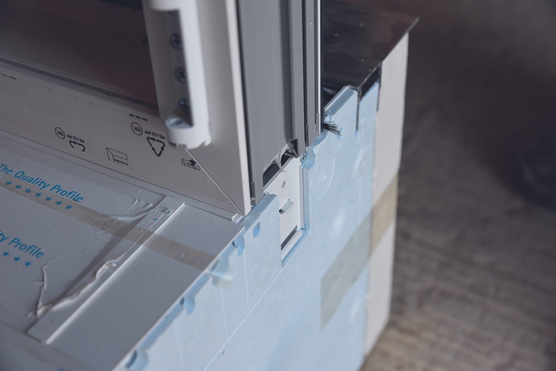 Um den Rollladenkasten Thermo NB 4.0 mit dem Blendrahmen zu verbinden, setzen Sie ihn leicht geneigt auf das Adapterprofil auf und rasten Sie ihn mit leichtem Druck ein. Montage-Tipp zum Aufbringen des Kastens: Legen Sie den Rollladenkasten auf den Boden, wobei das Bodenprofil nach oben zeigt. Drehen Sie dann den Blendrahmen auf den Kopf und verbinden Sie ihn mit dem Kasten.