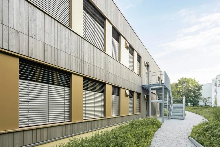 Die eingesetzten Warema Basis-Raffstoren E80 A6 S sind mit integriertem Tageslicht-Transportelement (TLT) ausgestattet. W&auml;hrend der untere Behangbereich verschattet, transportieren die oberen Lamellen Tageslicht gezielt in den Raum.